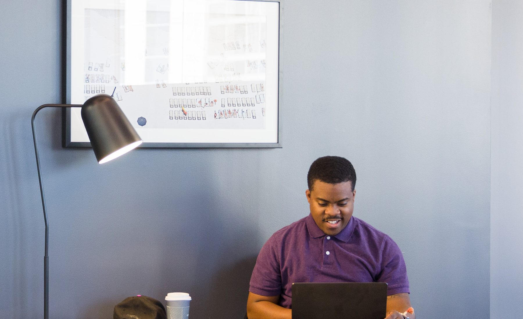 A professional working on a laptop in a lounge chair at a Charlotte coworking space used for Atlas AI consulting and training